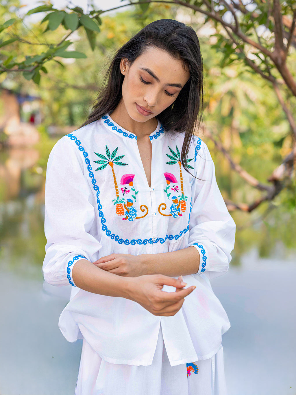 Detailed front view of symmetrical monkey embroidery and ruffled collar