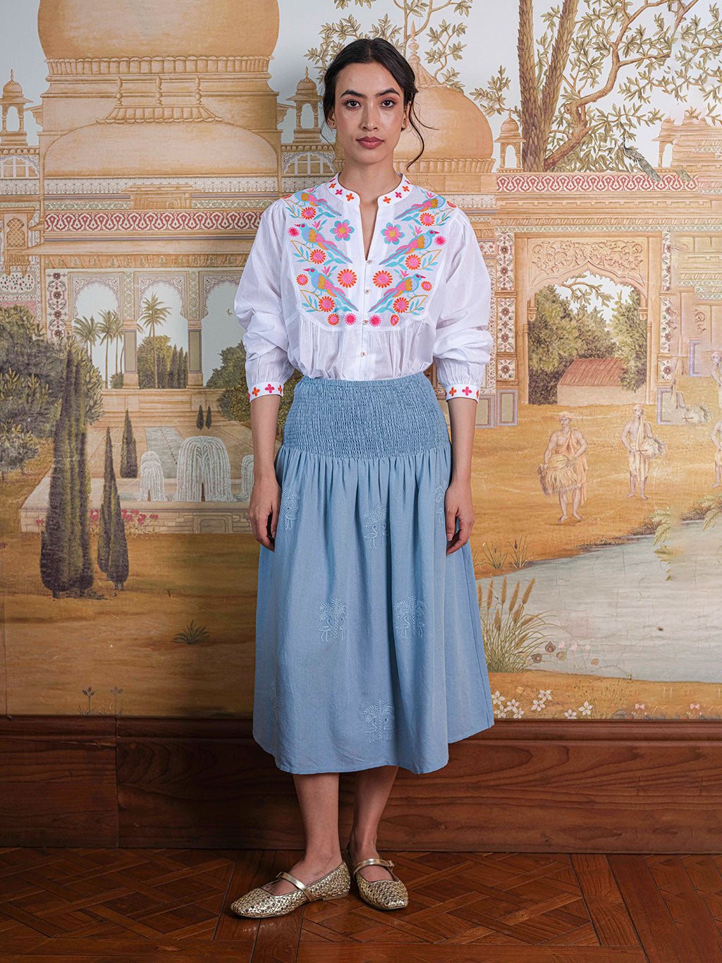 Model wearing the relaxed Catnep blouse in organic cotton, styled with a skirt for a luxury resort look.