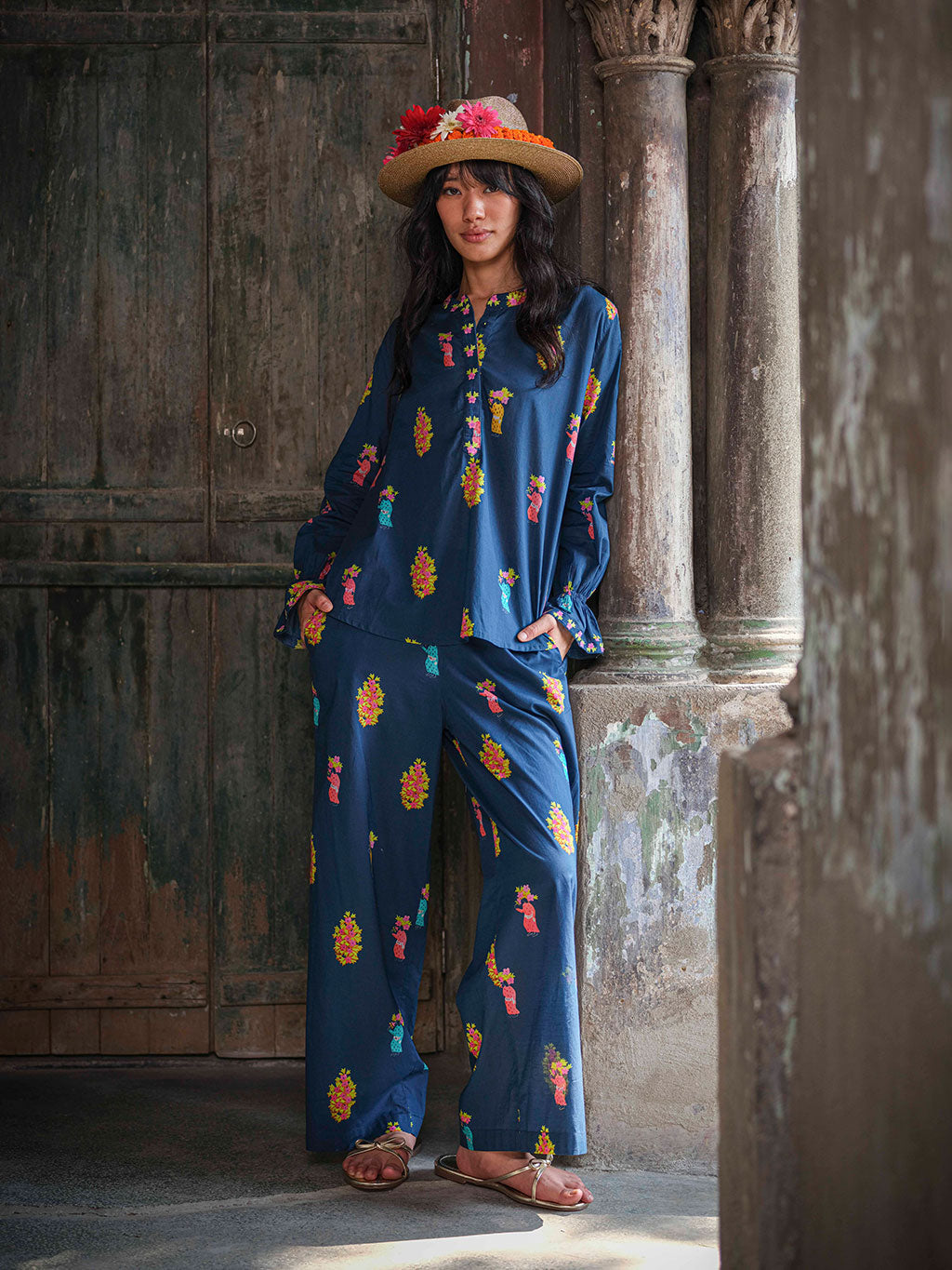 A coordinated resort look with a navy blue tunic top and wide summer pant, crafted from sustainable cotton with a bohemian print
