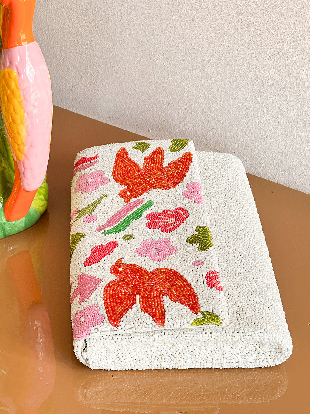 Envelope clutch with glass bead bird embroidery for elevated reosrt & summer looks, suitable for your next Portofino luxury stay.