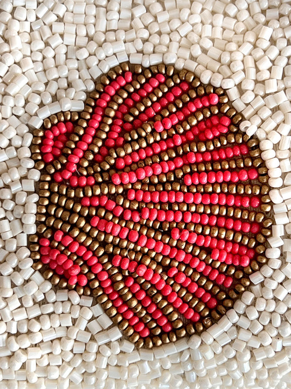 Close-up detail of hand-beaded scallop shell pattern on white glass seed bead evening bag