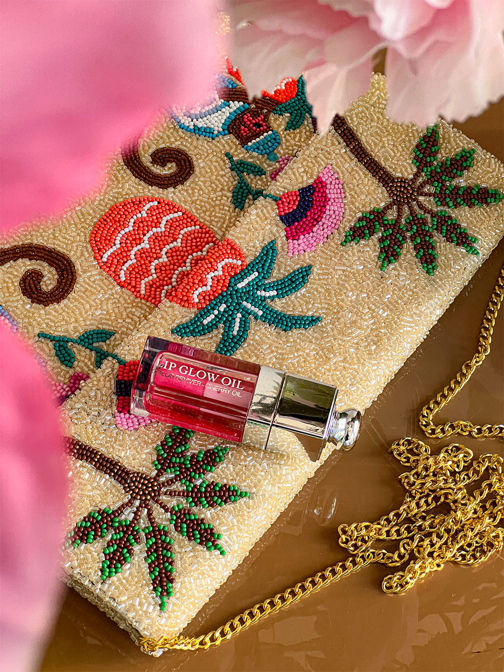 Nimo With Love Monkey Clutch styled with Dior lip oil — beaded evening bag with gold shoulder chain. Close view.