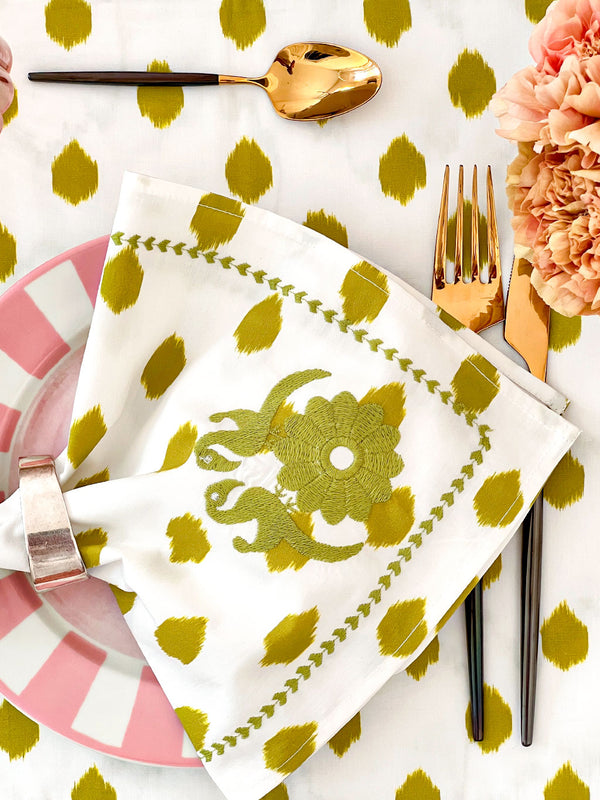 Close-up of tactile hand-embroidery and green ikat dot print