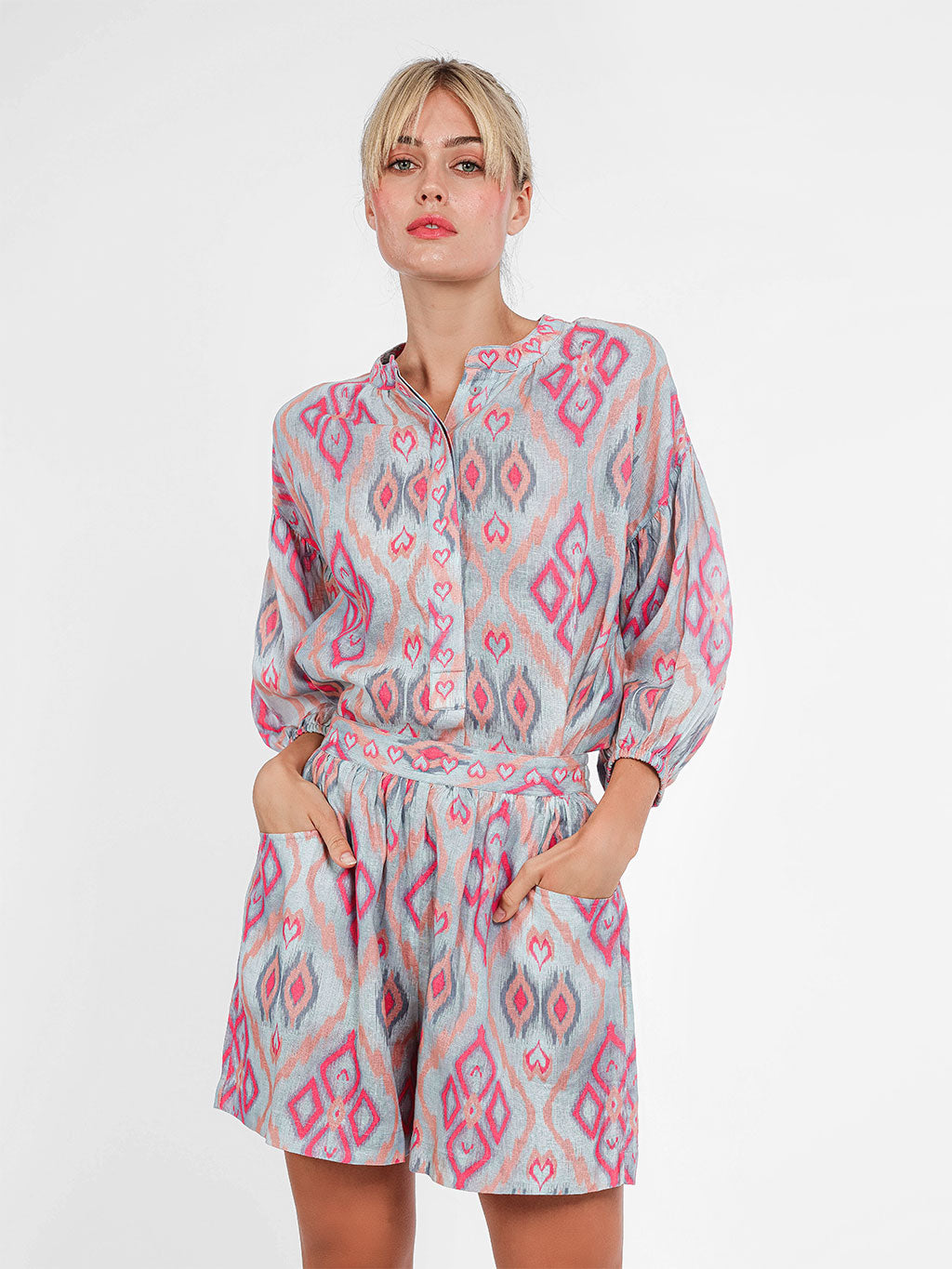 Model wearing the Lilly Pilly linen shorts in ikat sorbet, paired with a matching embroidered wrap blouse.