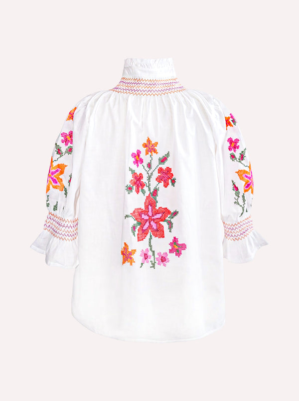 Back of the organic cotton Nimo Bergamot Blouse with colorful floral cross-stitch embroidery.