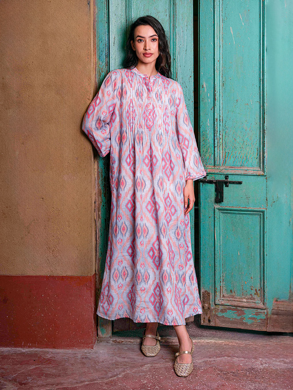 Model showcasing the graceful movement and inclusive fit of the pleated Woodruff linen dress outside an Indian palace.