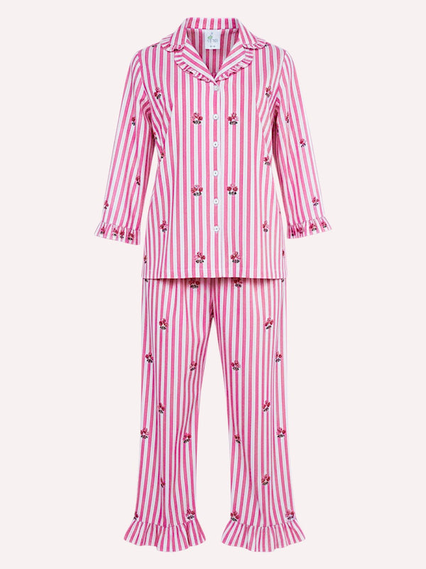 a luxury Nimo With Love two-piece girls' pajama set featuring pink and white vertical stripes with small embroidered floral motifs and ruffled trim on the collar, cuffs, and pant hems, shown against a plain light background.