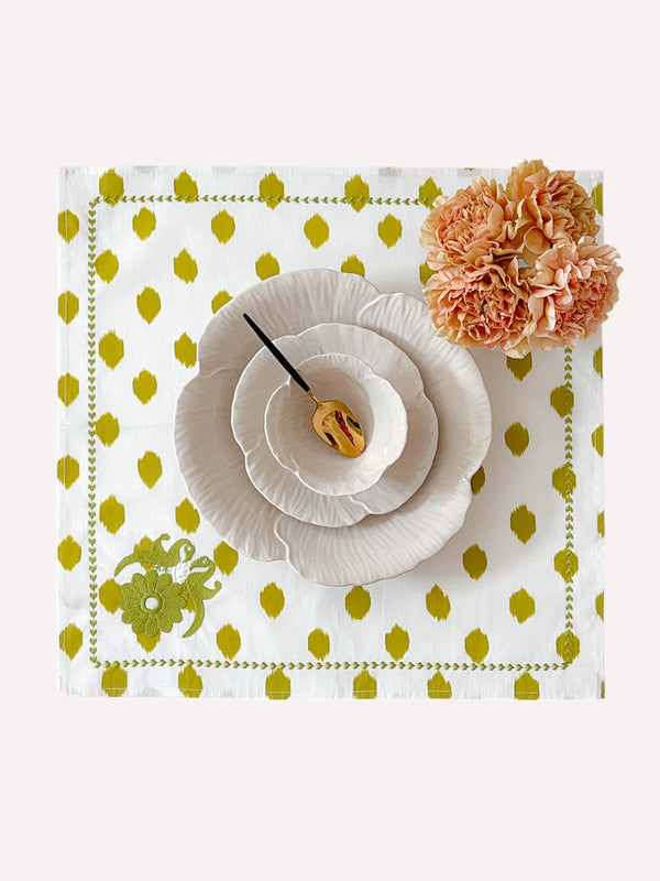Modern eclectic table decor featuring embroidered bird motifs in green
