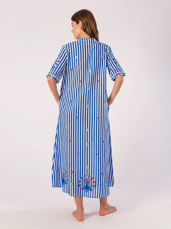 Woman wearing a blue and white striped maxi dress with floral embroidery