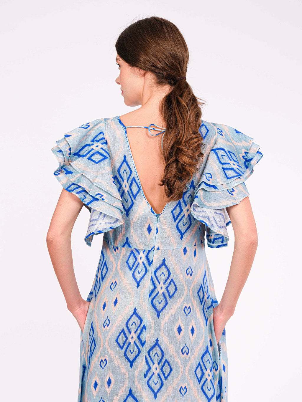 A ruffled summer dress with a deep, adjustable V-decolleté in the back 