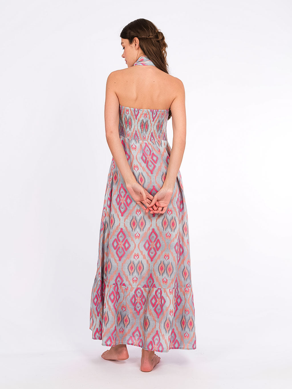 Rear view of the Caraway dress showcasing the flexible smocked back and the voluminous tiered skirt.
