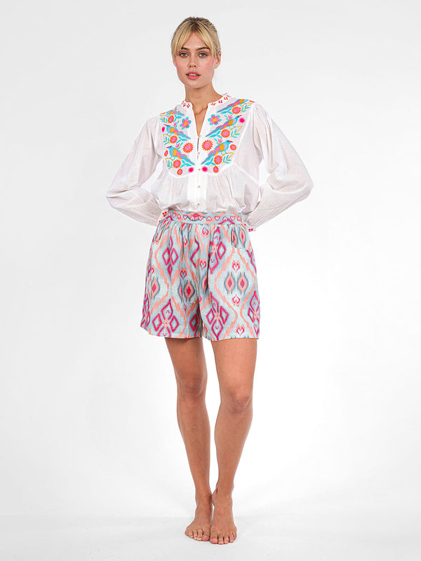 Model wearing the relaxed Catnep blouse in organic cotton, styled with patterned shorts for a luxury resort look.