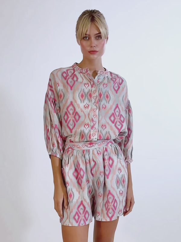 Video of a model wearing the Lilly Pilly linen shorts in ikat sorbet, paired with a matching embroidered wrap blouse.